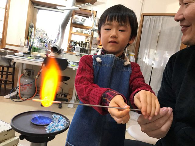 実際に火を使い、ガラス棒を溶かしてとんぼ玉を作る。スタッフのていねいな指導で、簡単にアクセサリーが作れる。